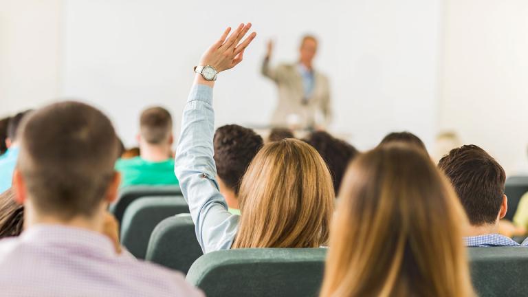 Student raising her hand to ask a question in class