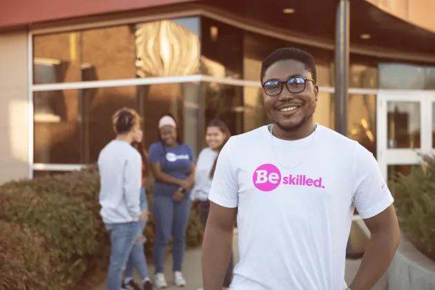 Student standing in front of campus entry wearing a Great Plains College t-shirt